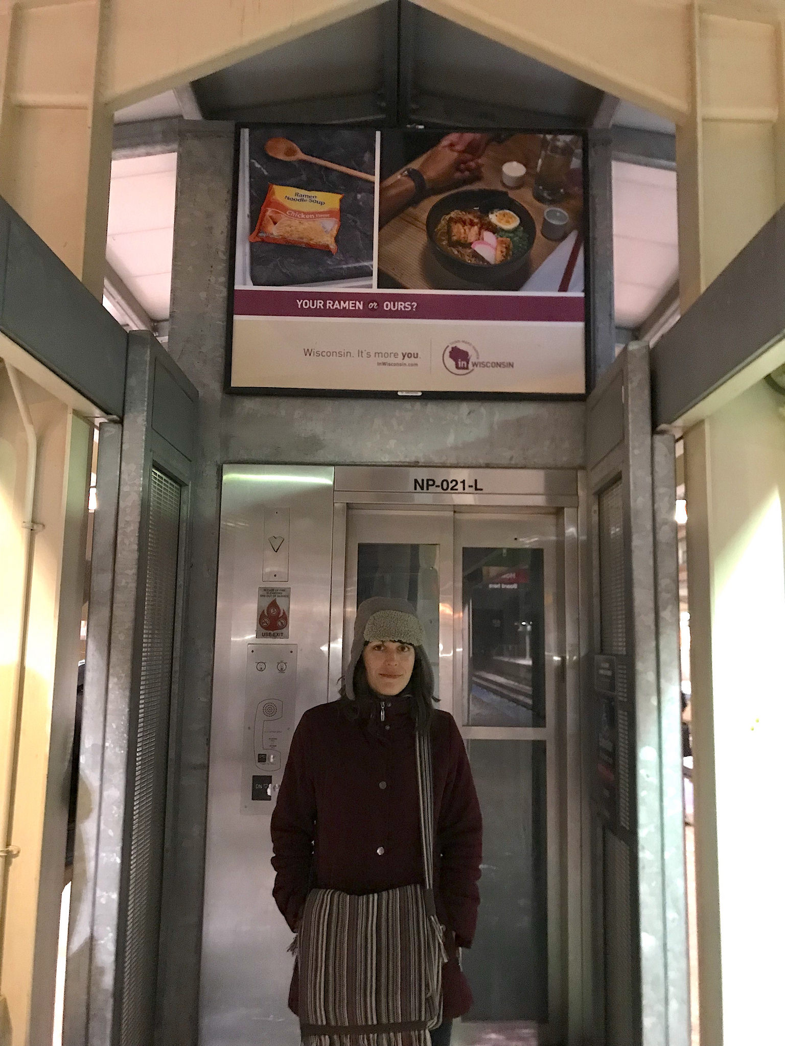 Marta Grabowski by a Wisconsin ad playing up the lower cost of living in the Badger State, asking "Your ramen or ours." Photo: John Greenfield