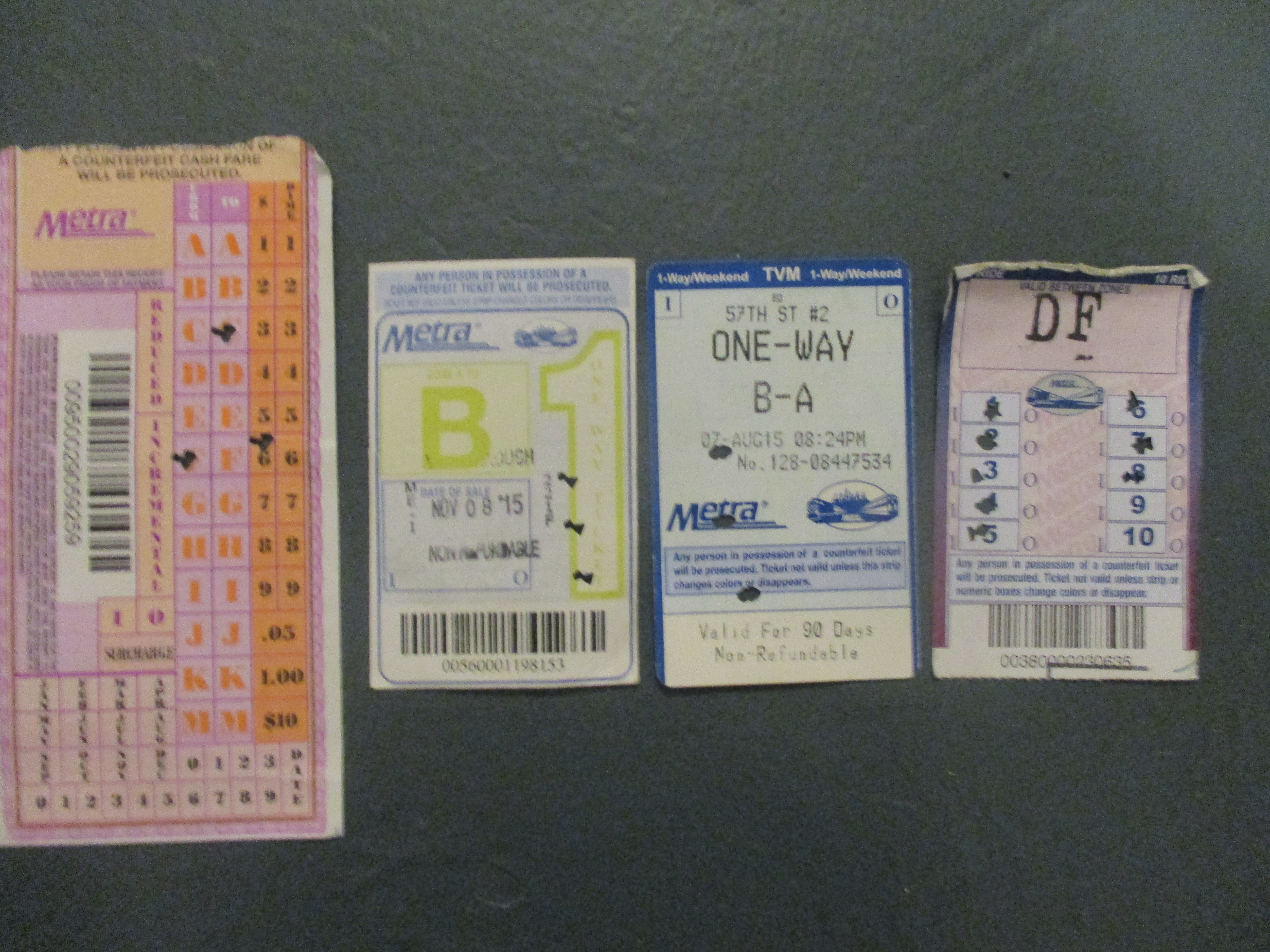 Riders can use Metra one-way and ten-ride passes to transfer by asking the conductor for one. The conductor punches an "I" or an "O" to indicate direction. They are located above the surcharge space on a one-way ticket purchased on the train (furthest left), at the lower portion of the date of "date of sale" stamp space in a ticket purchased from the ticket office (second from right), at the top corners of the ticket purchased from a machine (third from left) and around the spots marking the trip on the 10-ride ticket (right). Photo: Igor Studenkov