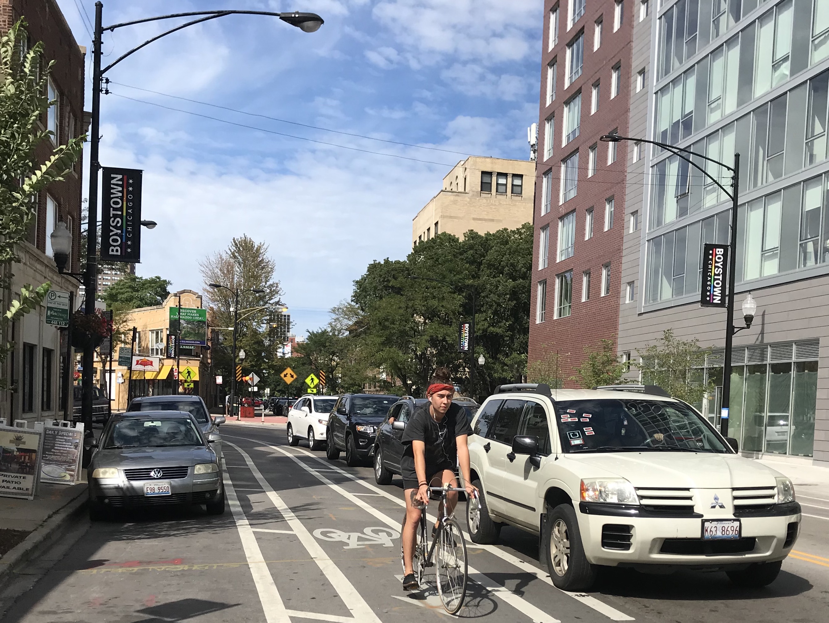 A cyclist uses adouble-buffered bike lane as intended, cycling in the center of the bikeable area, in the middle of the arrow. A more time rider might cycle closer to parked cars. Photo: John Greenfield