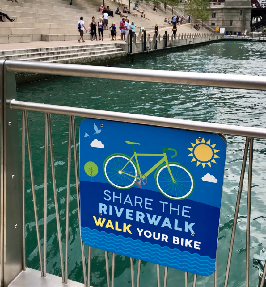 Ignore Those New Signs — It’s Legal to Bike on the Riverwalk