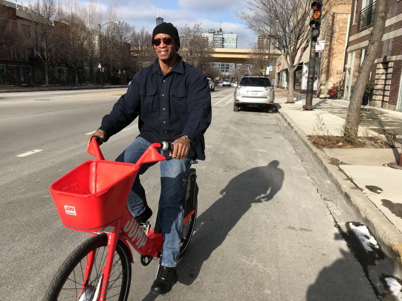 Arron Muhammad, owner of Akhira's Praline, Candy & Coffee House, test rides a Jump bike. Photo: John Greenfield