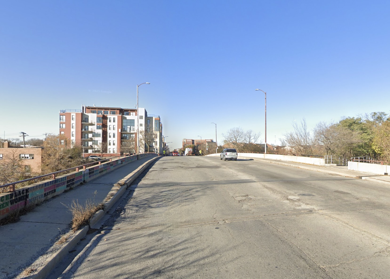 Belmont Avenue at the south end of the 312 RiverRun (the opening to an access ramp is visible at the right side of the image) looking west. Image: Google Maps